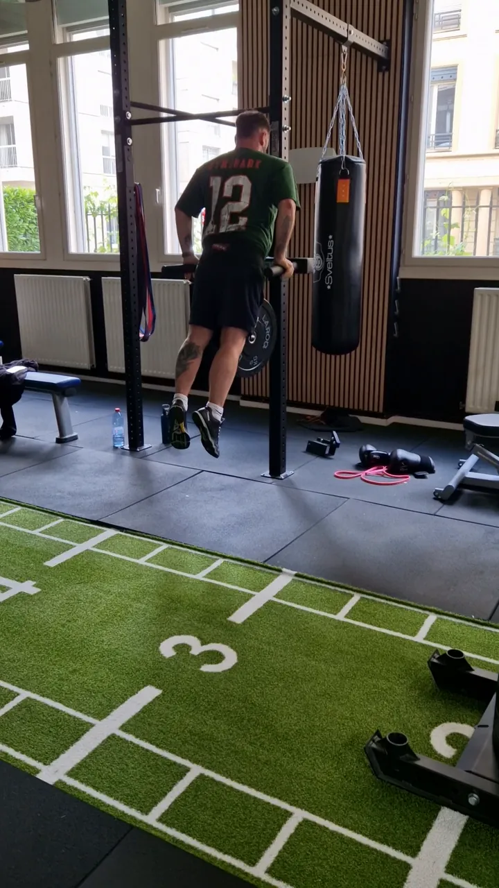 Dips devant un sac de frappe dans la salle lumineuse du studio Top Strength, à Lyon 6